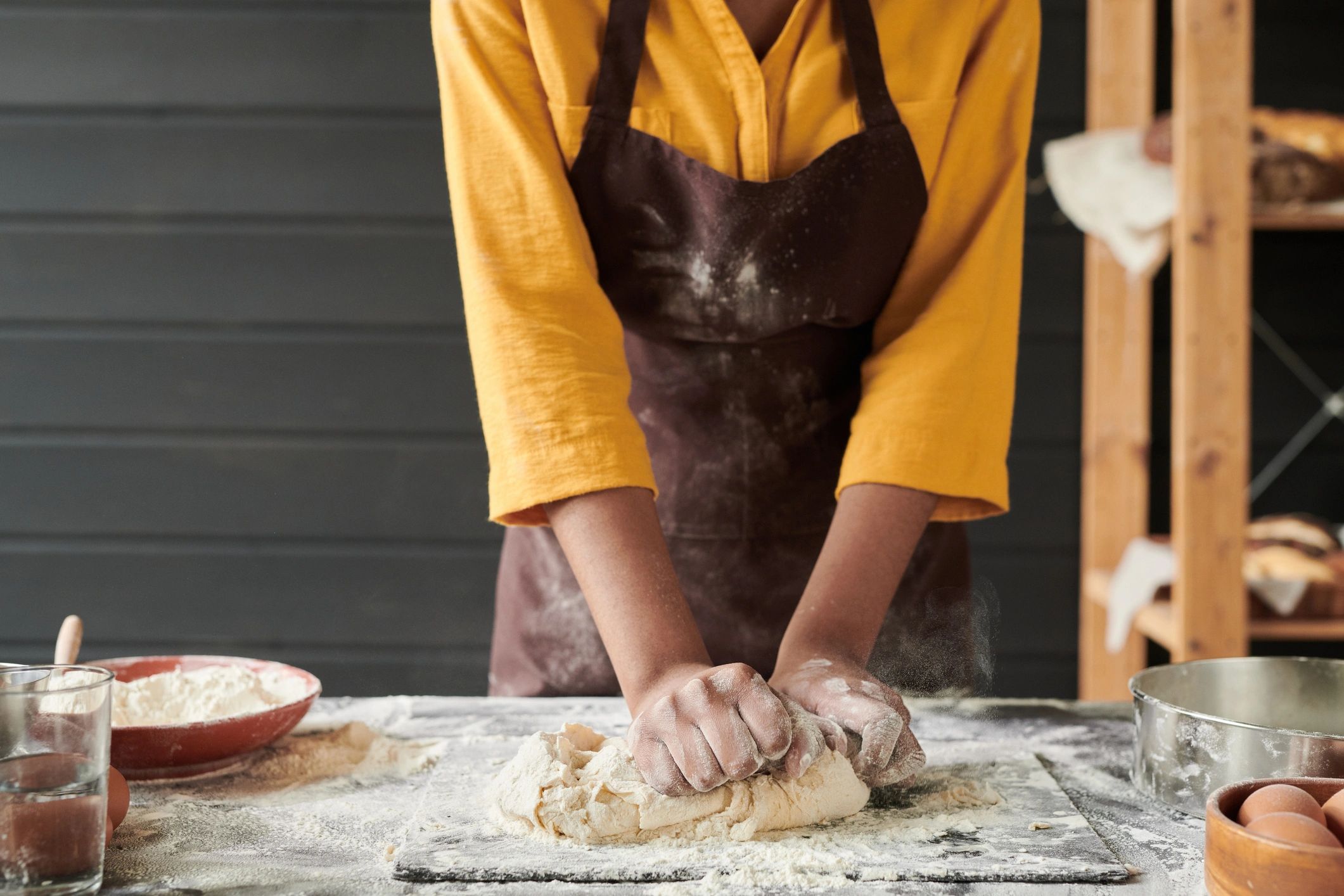 Close-up of a baker kneading dough on a work surface