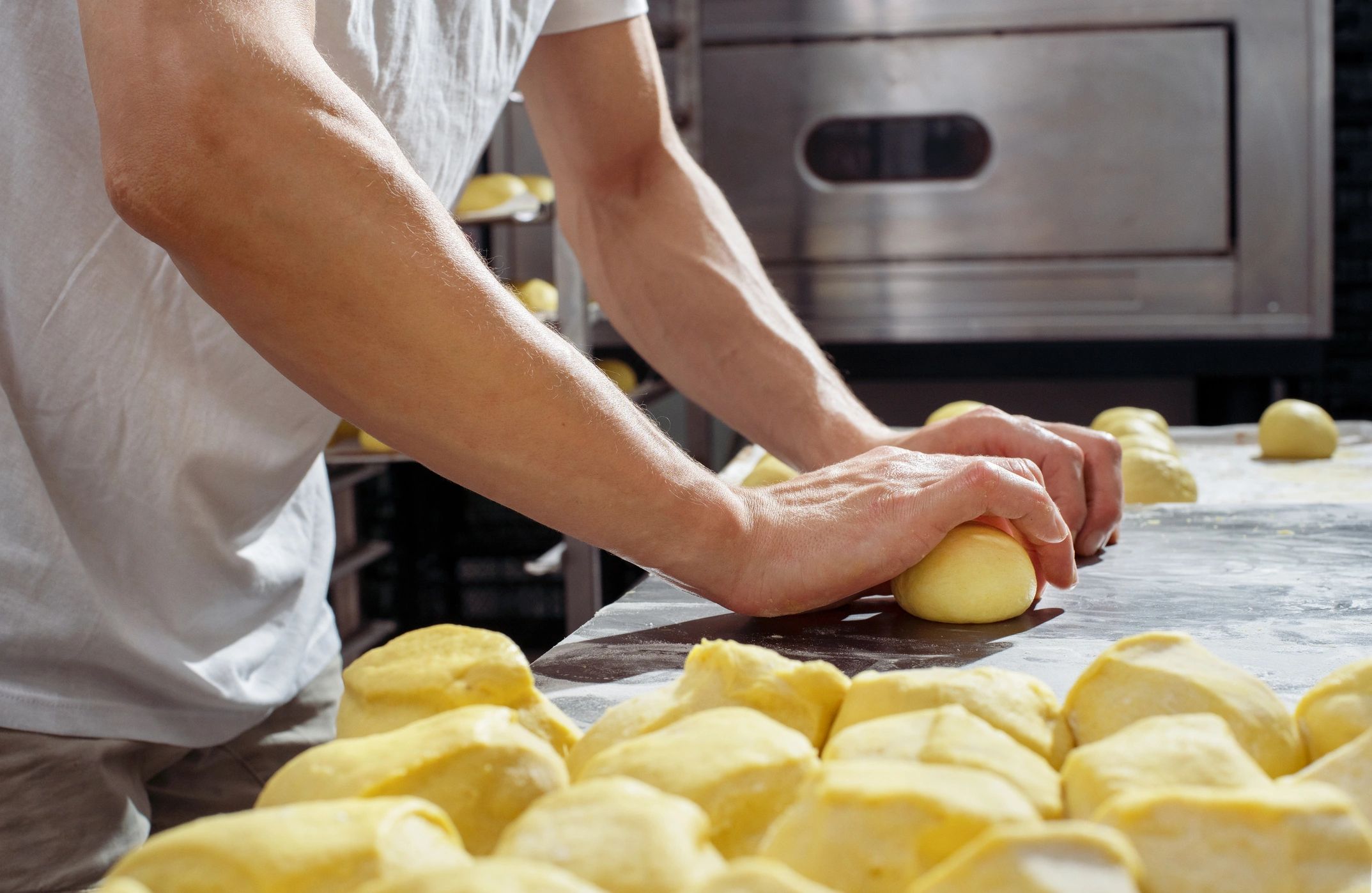Hands shaping dough in a bakery