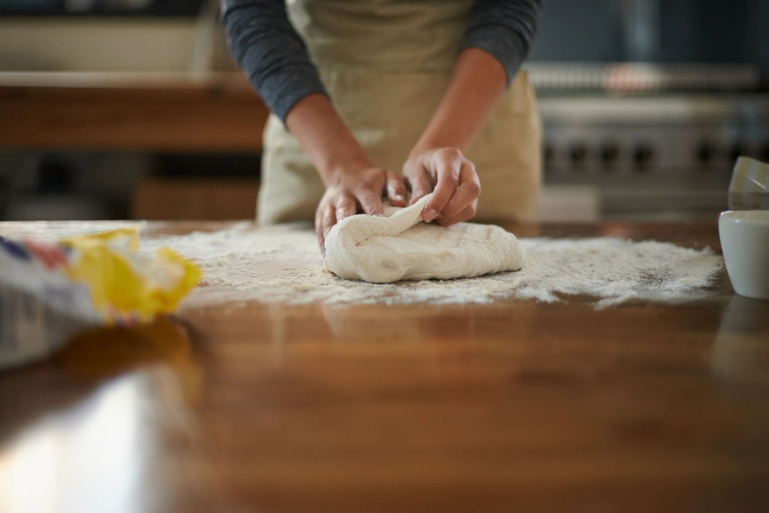 Baker kneading dough on a floured surface