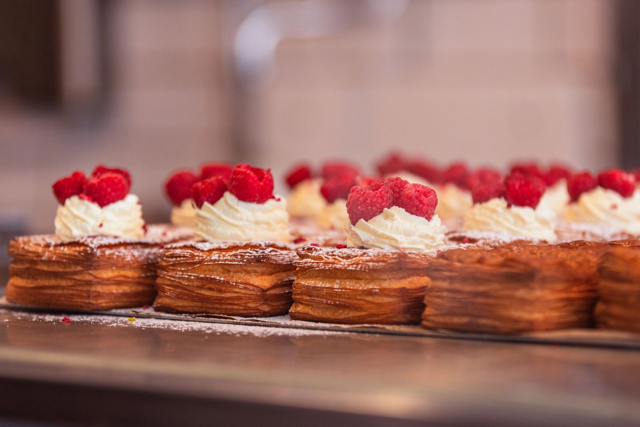 Pastry with cream and raspberry on display